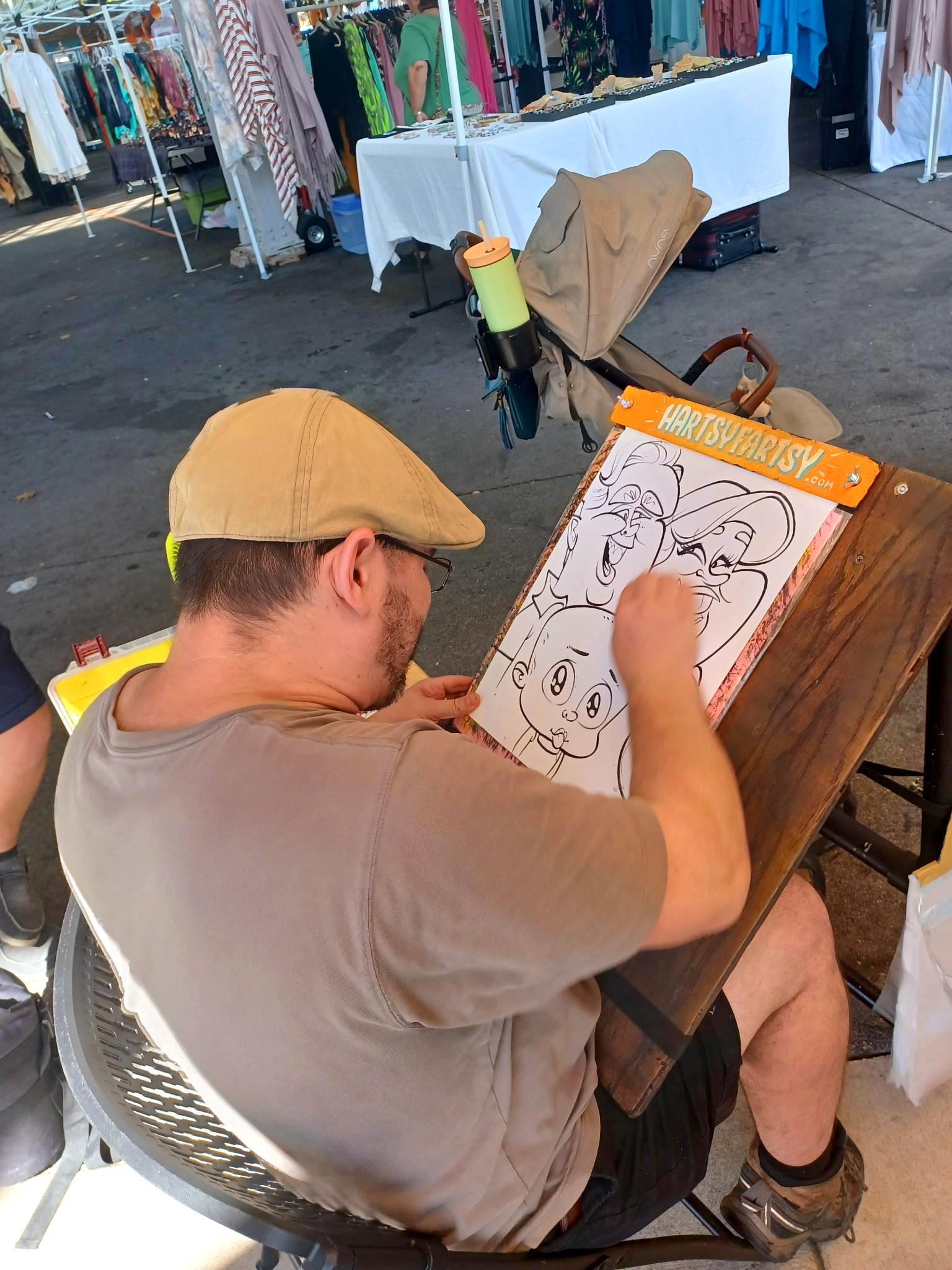 Dennis is finishing up on a black and white drawing at the market